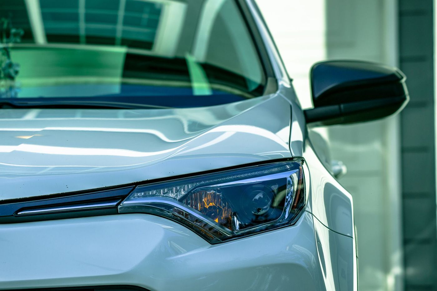 A clean, clear headlight lens on the front corner of a car. Stock photograph.